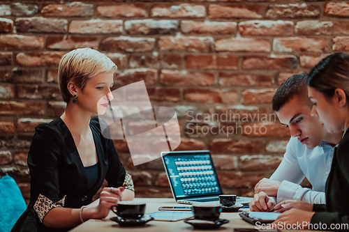 Image of Happy businesspeople smiling cheerfully during a meeting in a coffee shop. Group of successful business professionals working as a team in a multicultural workplace.