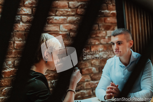 Image of Happy businesspeople smiling cheerfully during a meeting in a coffee shop. Group of successful business professionals working as a team in a multicultural workplace.