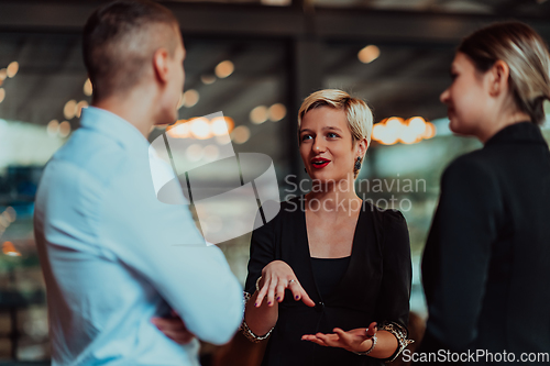 Image of Photo of a business team of young people discussing business ideas in a modern urban environment. Selective focus