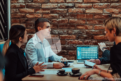 Image of Happy businesspeople smiling cheerfully during a meeting in a coffee shop. Group of successful business professionals working as a team in a multicultural workplace.