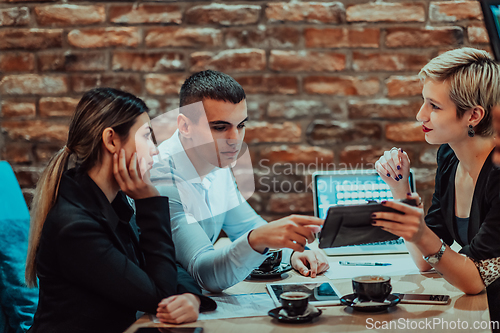 Image of Happy businesspeople smiling cheerfully during a meeting in a coffee shop. Group of successful business professionals working as a team in a multicultural workplace.