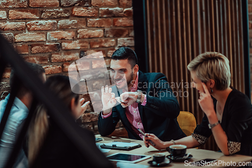 Image of Happy businesspeople smiling cheerfully during a meeting in a coffee shop. Group of successful business professionals working as a team in a multicultural workplace.