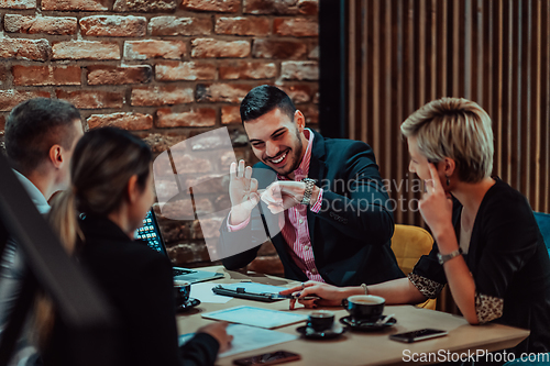 Image of Happy businesspeople smiling cheerfully during a meeting in a coffee shop. Group of successful business professionals working as a team in a multicultural workplace.