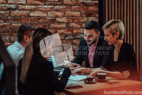 Image of Happy businesspeople smiling cheerfully during a meeting in a coffee shop. Group of successful business professionals working as a team in a multicultural workplace.