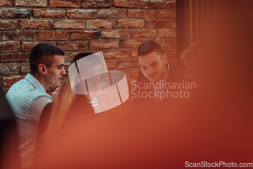 Image of Happy businesspeople smiling cheerfully during a meeting in a coffee shop. Group of successful business professionals working as a team in a multicultural workplace.