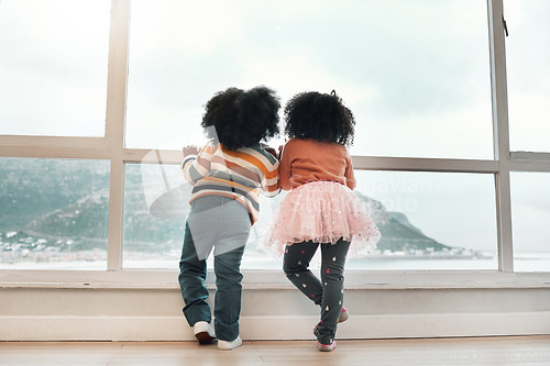 Image of Window, looking and back of children with view of ocean, mountain and nature landscape from home. Childhood, relax and kids by glass waiting to play outdoors by sea on holiday, vacation and weekend