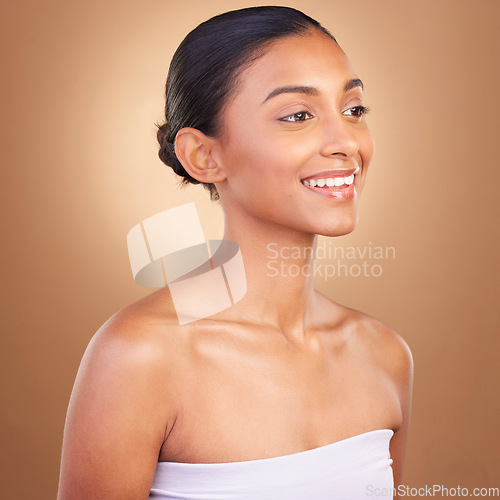 Image of Beauty, skincare and face of Indian woman with smile for wellness, glowing skin and spa treatment. Luxury salon, dermatology and happy girl in studio with cosmetics, natural makeup and confidence