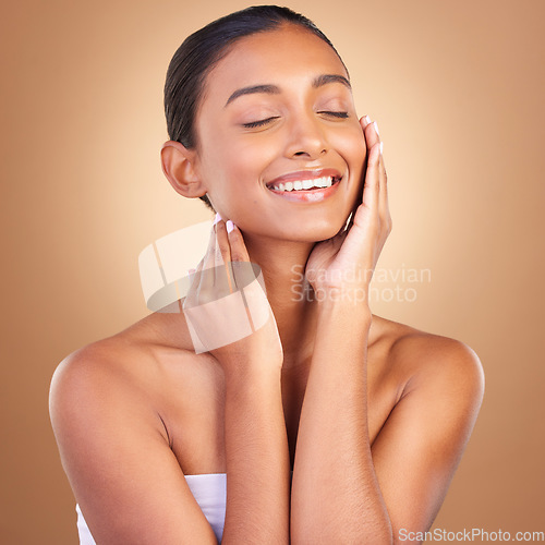 Image of Beauty, skincare and touch with indian woman in studio for happy, spa treatment and facial. Cosmetics, self care and glow with model on brown background for satisfaction, empowerment and confidence