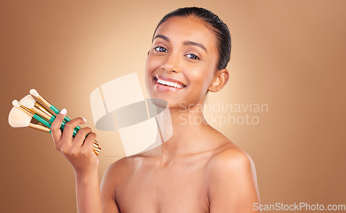 Image of Makeup brushes, smile and portrait of woman with natural beauty, wellness and happiness from cosmetics. Facial skin glow, happy and cosmetic face brush of a female model with self care in a studio