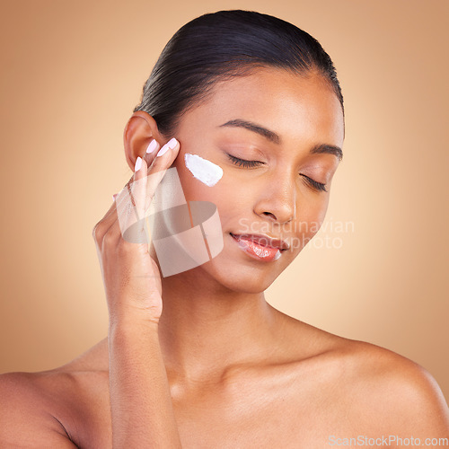 Image of Beauty, skincare and face of Indian woman with cream in studio for wellness, glowing and spa products. Salon, dermatology and girl with lotion cosmetics, moisturizer makeup and anti aging products
