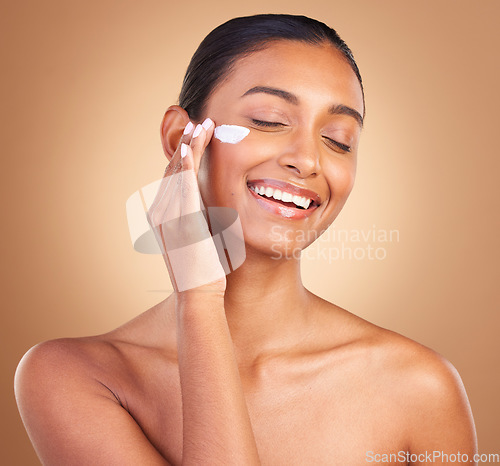 Image of Skincare beauty, sunscreen and laugh of a happy woman with cosmetic and cream. Isolated, studio background and young model with a smile from face cleaning, cosmetics and dermatology facial product.