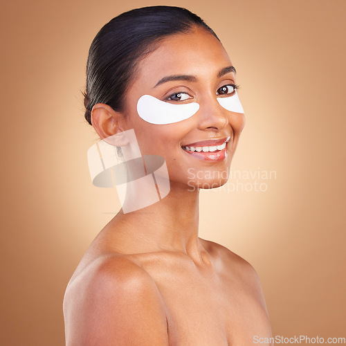 Image of Happy, eye patch and beauty with Indian woman for facial, spa treatment and glow. Self care, cosmetics and hydration with female model on brown background for skincare mask, product and youth