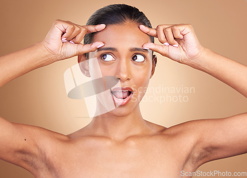 Image of Beauty health, surprise and woman forehead wrinkles with a female squeeze face with shock. Isolated, studio background and cosmetic change of a model holding clean skin for plastic surgery