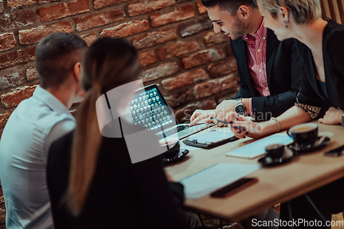 Image of Happy businesspeople smiling cheerfully during a meeting in a coffee shop. Group of successful business professionals working as a team in a multicultural workplace.