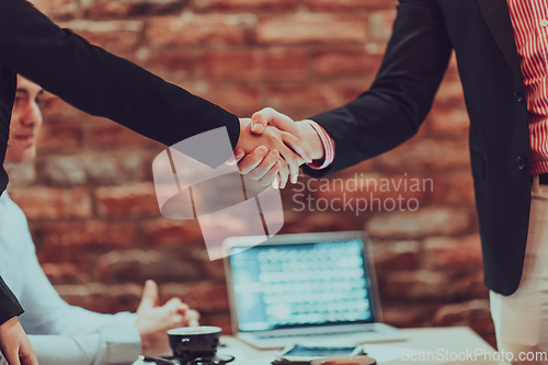 Image of Business shaking hands, finishing up meeting. Successful businesspeople handshaking after good deal