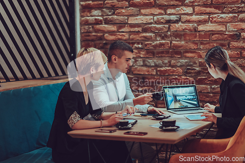 Image of Happy businesspeople smiling cheerfully during a meeting in a coffee shop. Group of successful business professionals working as a team in a multicultural workplace.