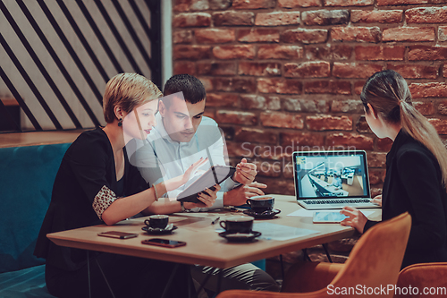 Image of Happy businesspeople smiling cheerfully during a meeting in a coffee shop. Group of successful business professionals working as a team in a multicultural workplace.