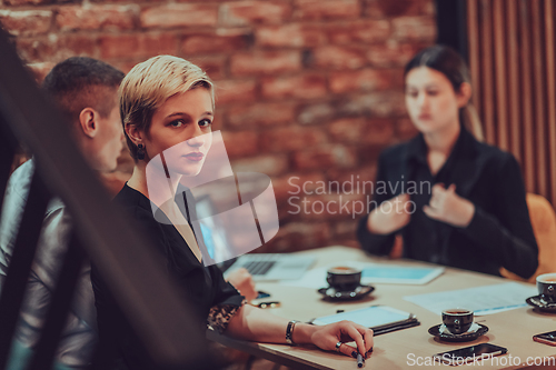 Image of Happy businesspeople smiling cheerfully during a meeting in a coffee shop. Group of successful business professionals working as a team in a multicultural workplace.