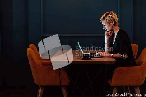 Image of Businesswoman sitting in a cafe while focused on working on a laptop and participating in an online meetings. Selective focus.