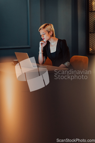 Image of Businesswoman sitting in a cafe while focused on working on a laptop and participating in an online meetings. Selective focus.