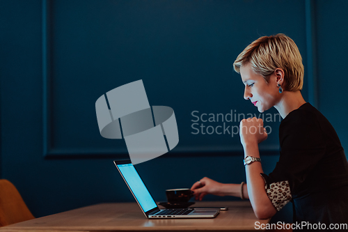 Image of Businesswoman sitting in a cafe while focused on working on a laptop and participating in an online meetings. Selective focus.