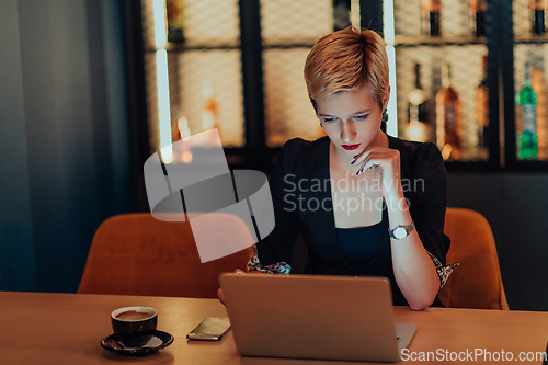 Image of Businesswoman sitting in a cafe while focused on working on a laptop and participating in an online meetings. Selective focus.