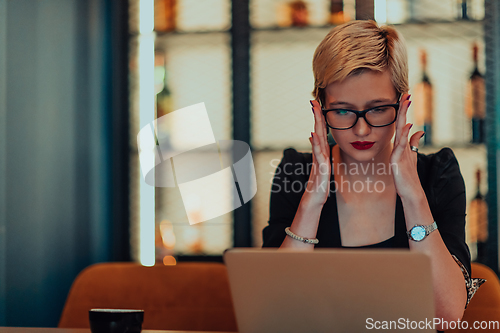 Image of Businesswoman sitting in a cafe while focused on working on a laptop and participating in an online meetings. Selective focus.