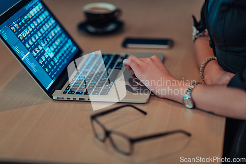 Image of Close up photo of businesswoman sitting in a cafe while focused on working on a laptop and participating in an online meetings. Selective focus.