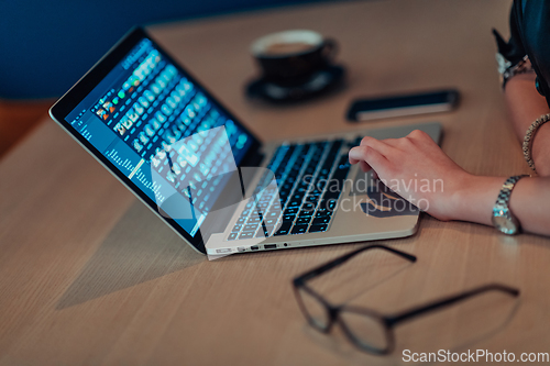 Image of Close up photo of businesswoman sitting in a cafe while focused on working on a laptop and participating in an online meetings. Selective focus.