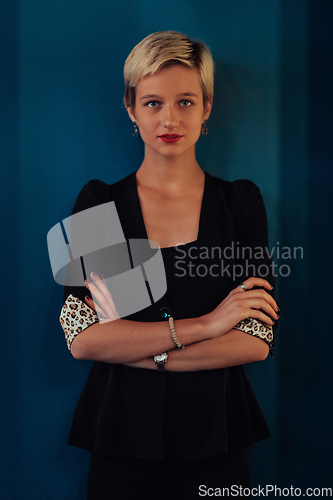 Image of Blonde business woman, successful confidence with arms crossed on modern blue mat background. Selective focus