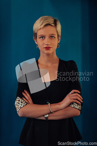 Image of Blonde business woman, successful confidence with arms crossed on modern blue mat background. Selective focus