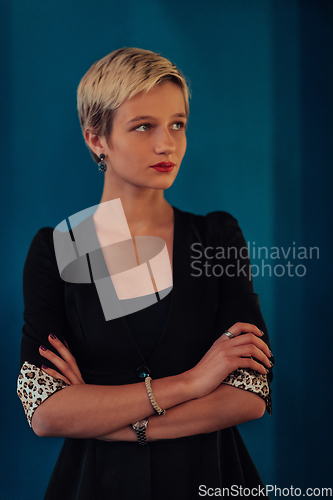 Image of Blonde business woman, successful confidence with arms crossed on modern blue mat background. Selective focus