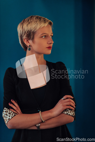 Image of Blonde business woman, successful confidence with arms crossed on modern blue mat background. Selective focus