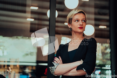 Image of Business woman in a black suit, successful confidence with arms crossed in modern office