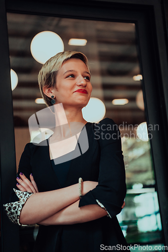 Image of Business woman in a black suit, successful confidence with arms crossed in modern office