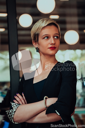 Image of Business woman in a black suit, successful confidence with arms crossed in modern office