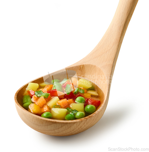 Image of vegetable soup in wooden ladle