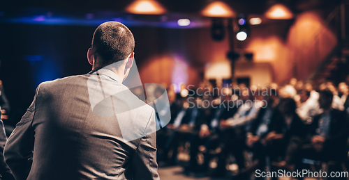 Image of Public speaker giving talk at Business Event.