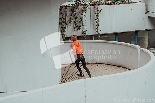 Image of Women in sports clothes running in a modern urban environment. The concept of a sporty and healthy lifestyle