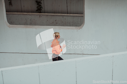 Image of Women in sports clothes running in a modern urban environment. The concept of a sporty and healthy lifestyle