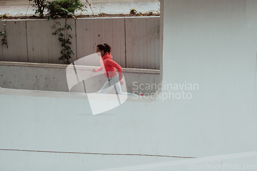 Image of Women in sports clothes running in a modern urban environment. The concept of a sporty and healthy lifestyle