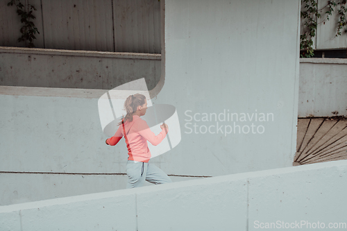 Image of Women in sports clothes running in a modern urban environment. The concept of a sporty and healthy lifestyle