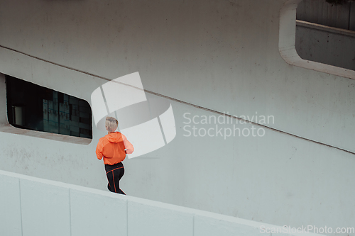 Image of Women in sports clothes running in a modern urban environment. The concept of a sporty and healthy lifestyle