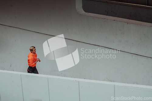 Image of Women in sports clothes running in a modern urban environment. The concept of a sporty and healthy lifestyle