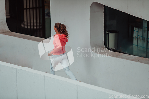 Image of Women in sports clothes running in a modern urban environment. The concept of a sporty and healthy lifestyle