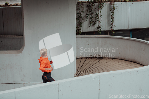 Image of Women in sports clothes running in a modern urban environment. The concept of a sporty and healthy lifestyle