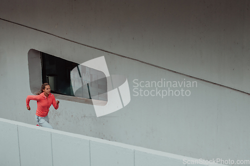 Image of Women in sports clothes running in a modern urban environment. The concept of a sporty and healthy lifestyle