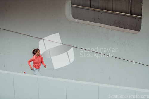 Image of Women in sports clothes running in a modern urban environment. The concept of a sporty and healthy lifestyle