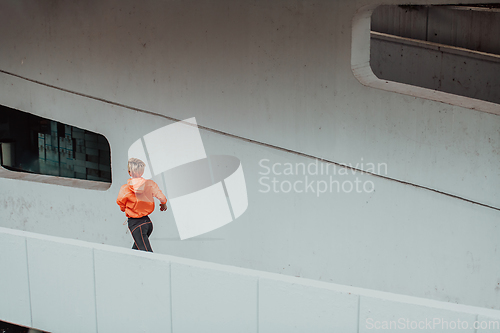 Image of Women in sports clothes running in a modern urban environment. The concept of a sporty and healthy lifestyle