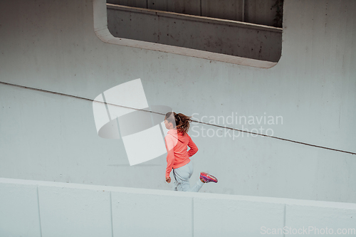 Image of Women in sports clothes running in a modern urban environment. The concept of a sporty and healthy lifestyle